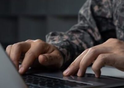 military man typing on computer